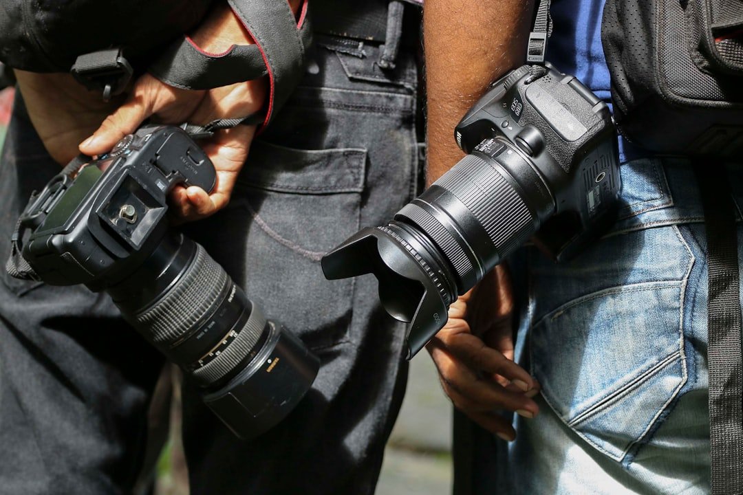 person-in-black-jacket-holding-black-dslr-camera-fhg8wlt01-g